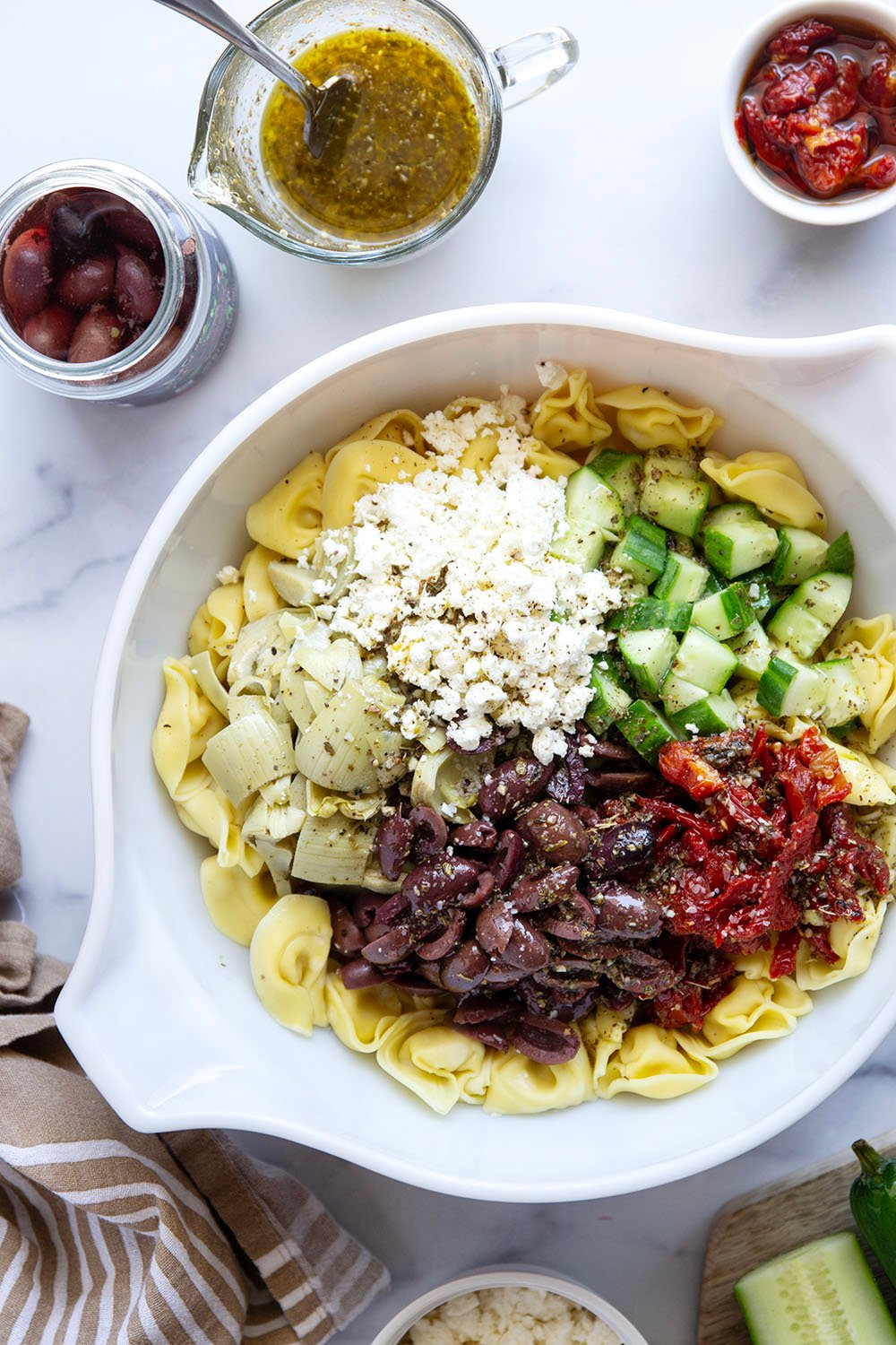 Bring this fresh Mediterranean tortellini pasta salad to any picnic and watch it disappear! Loaded with a rainbow of Mediterranean ingredients and tossed in a tangy white wine vinaigrette.