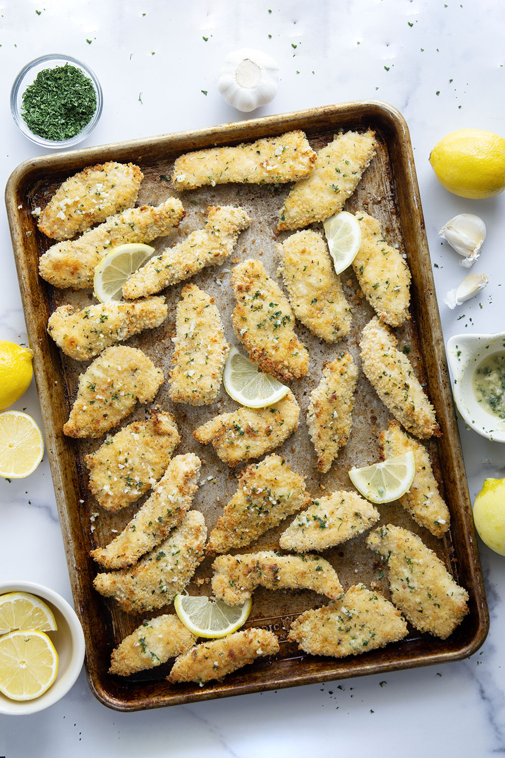 Oven fried to perfection until perfectly crispy and drizzled with a fresh lemon garlic butter, these lemon chicken tenders are always a dinner favorite.