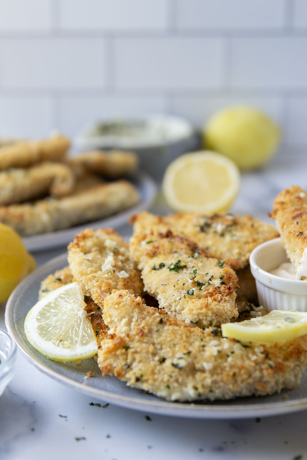 Oven fried to perfection until perfectly crispy and drizzled with a fresh lemon garlic butter, these lemon chicken tenders are always a dinner favorite.