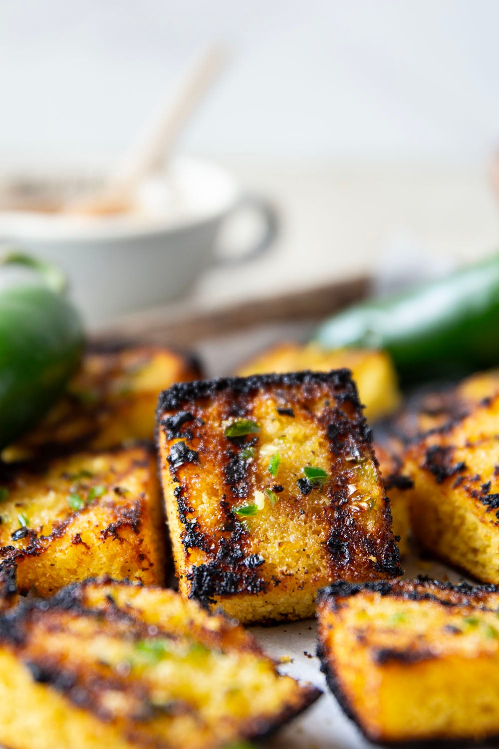 This grilled cornbread features homemade cornbread squares spread with a spicy jalapeno honey butter and then quickly cooked on the grill until perfectly crispy!