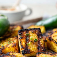 This grilled cornbread features homemade cornbread squares spread with a spicy jalapeno honey butter and then quickly cooked on the grill until perfectly crispy!