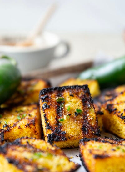 This grilled cornbread features homemade cornbread squares spread with a spicy jalapeno honey butter and then quickly cooked on the grill until perfectly crispy!