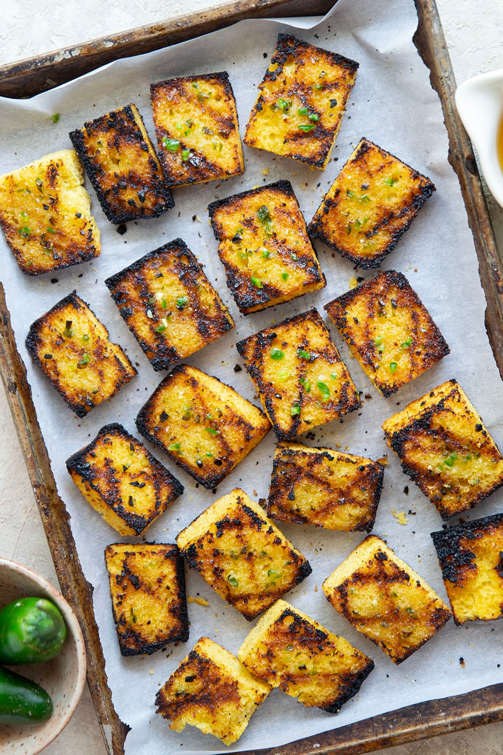 This grilled cornbread features homemade cornbread squares spread with a spicy jalapeno honey butter and then quickly cooked on the grill until perfectly crispy!