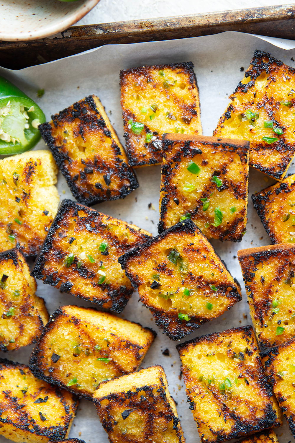This grilled cornbread features homemade cornbread squares spread with a spicy jalapeno honey butter and then quickly cooked on the grill until perfectly crispy!