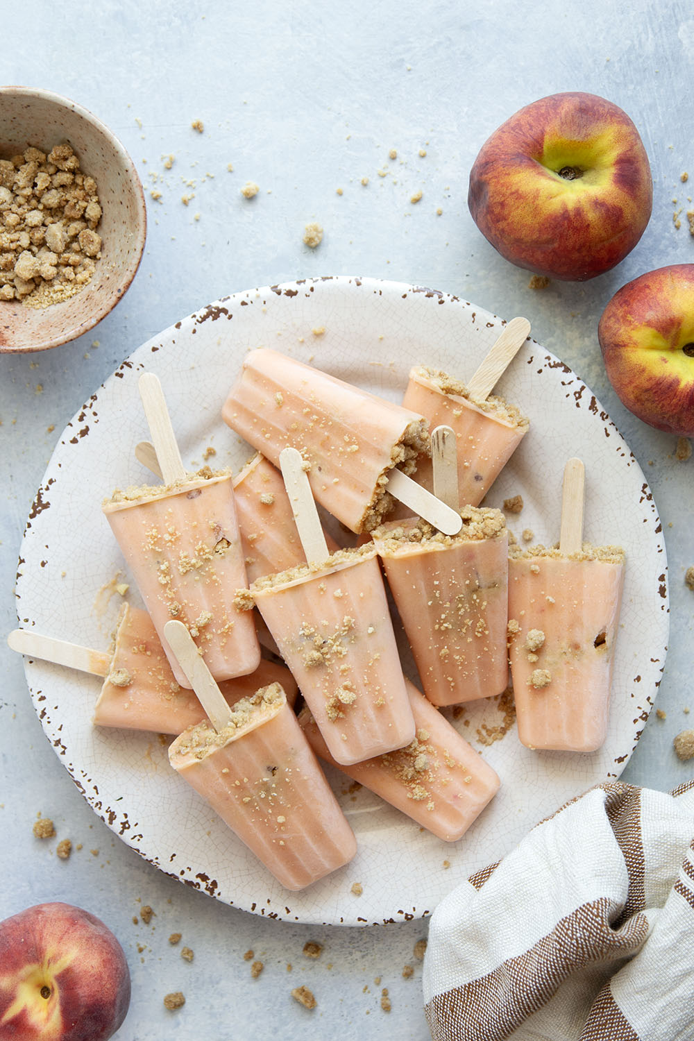 Juicy summer peaches and a crunchy brown sugar streusel are the perfect match in these multi-layered peach popsicles!