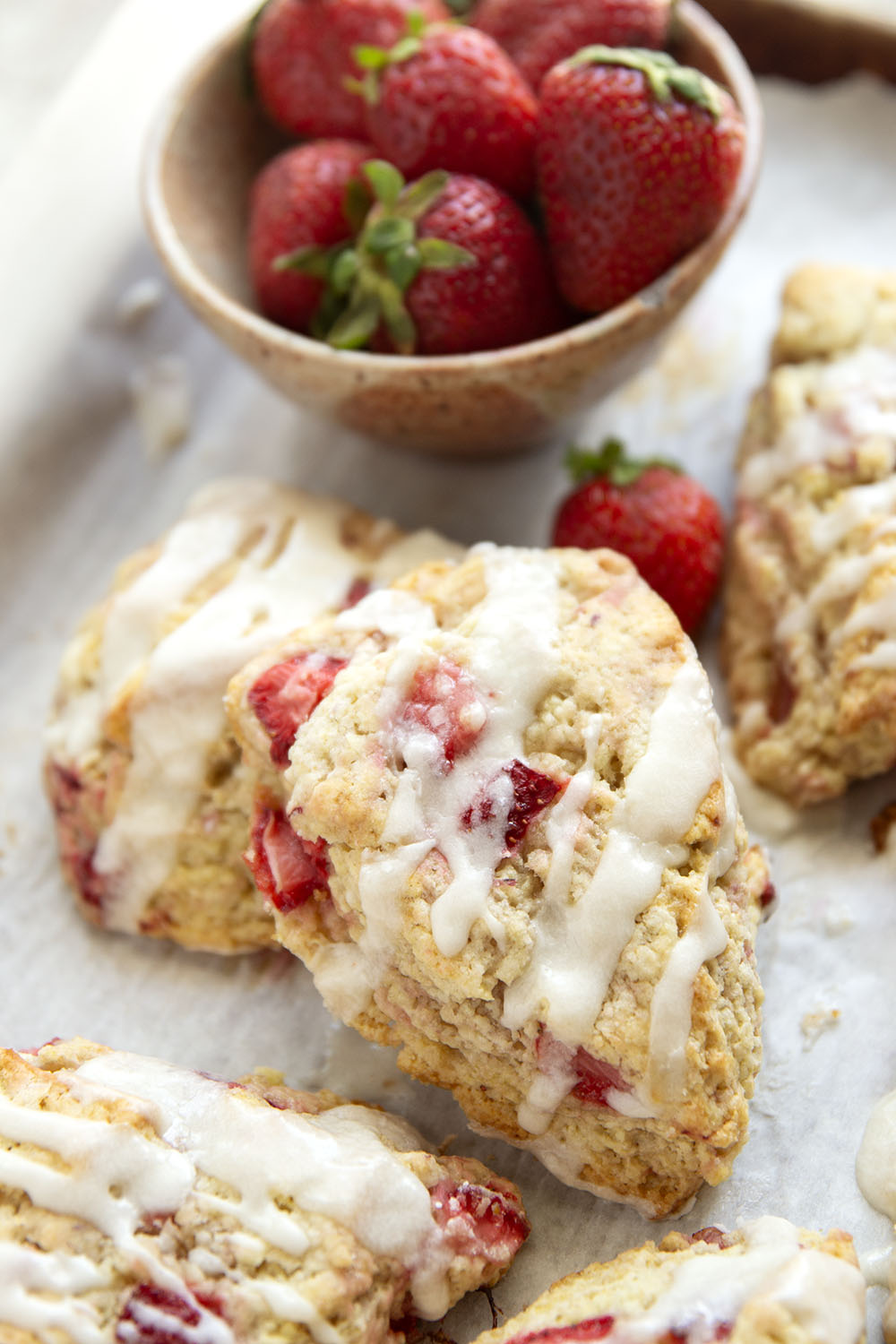 Loaded with little bursts of fresh strawberries and drizzled with a rich sweet cream glaze, these flaky strawberries and cream scones are always the most popular pastry on the table!