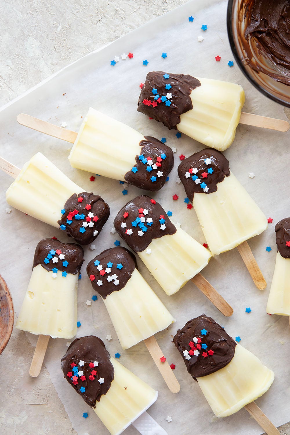 These vanilla pudding popsicles feature creamy homemade vanilla pudding frozen into pops and dipped in chocolate. Keep these stocked in your freezer all summer!