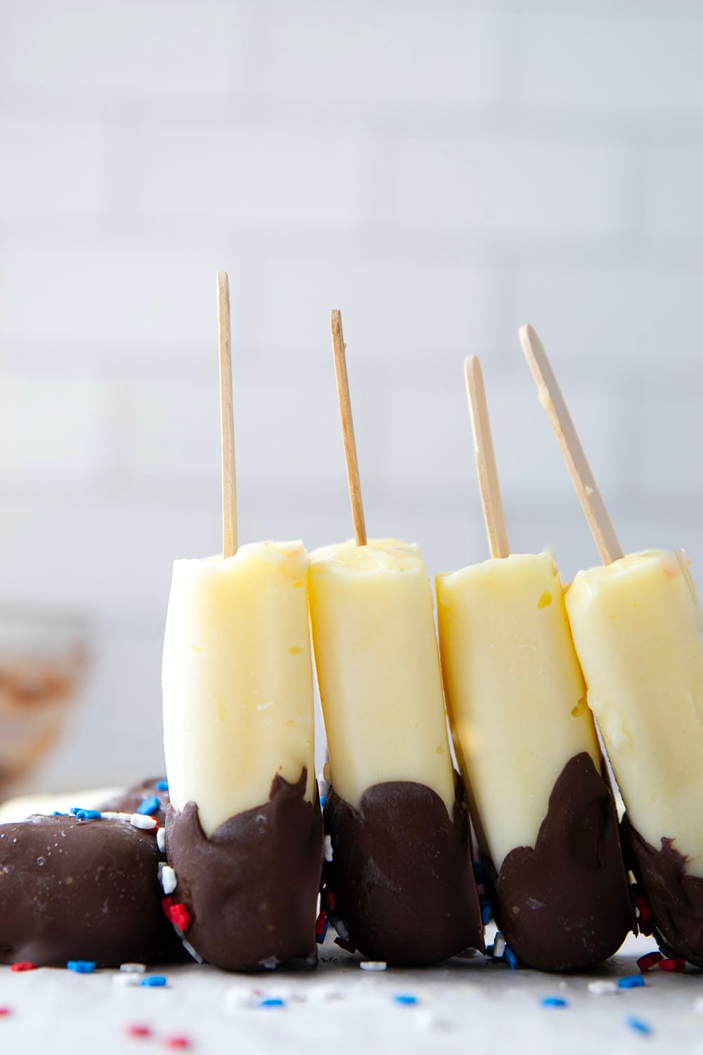 These vanilla pudding popsicles feature creamy homemade vanilla pudding frozen into pops and dipped in chocolate. Keep these stocked in your freezer all summer!