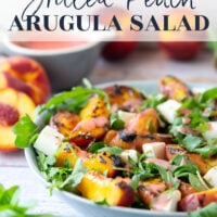 This peach arugula summer salad is loaded to the max with sweet grilled peach wedges, soft mozzarella cubes, and the most incredible homemade raspberry vinaigrette.