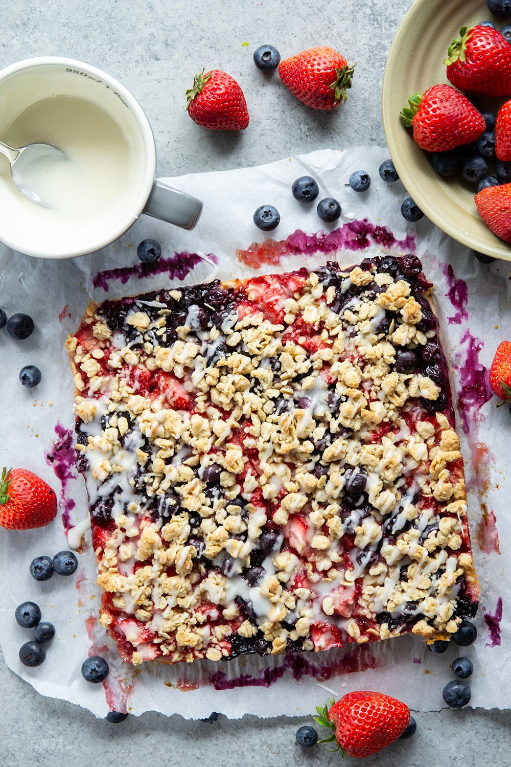 Loaded with a double whammy of berries, lots of streusel, and a creamy vanilla glaze, these red white and blue bars are an easy, festive treat for the 4th of July!