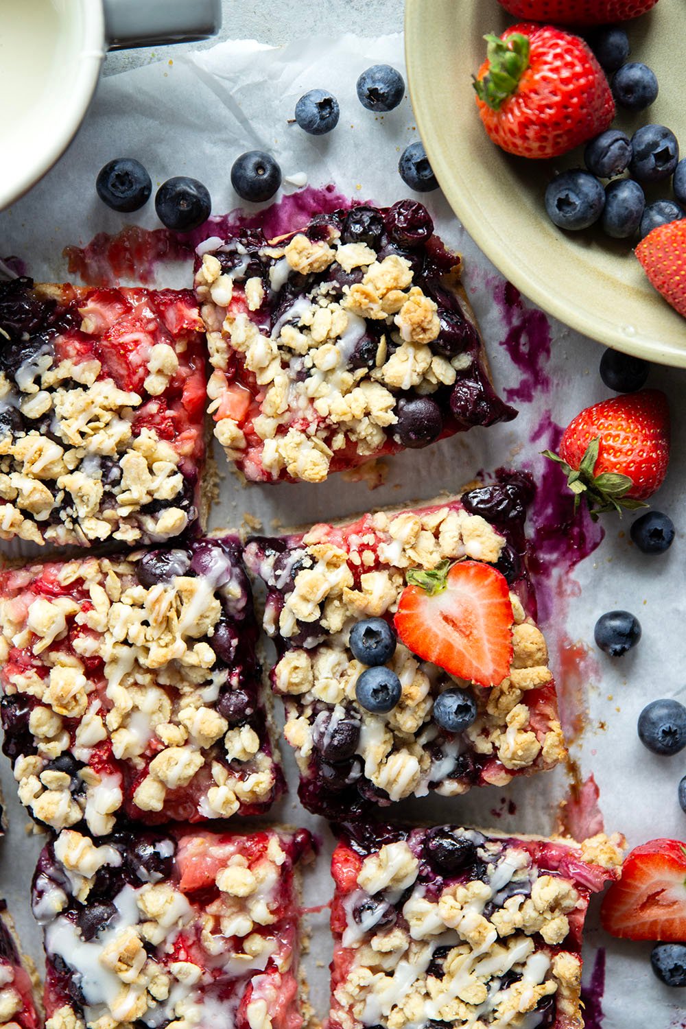 Loaded with a double whammy of berries, lots of streusel, and a creamy vanilla glaze, these red white and blue bars are an easy, festive treat for the 4th of July!