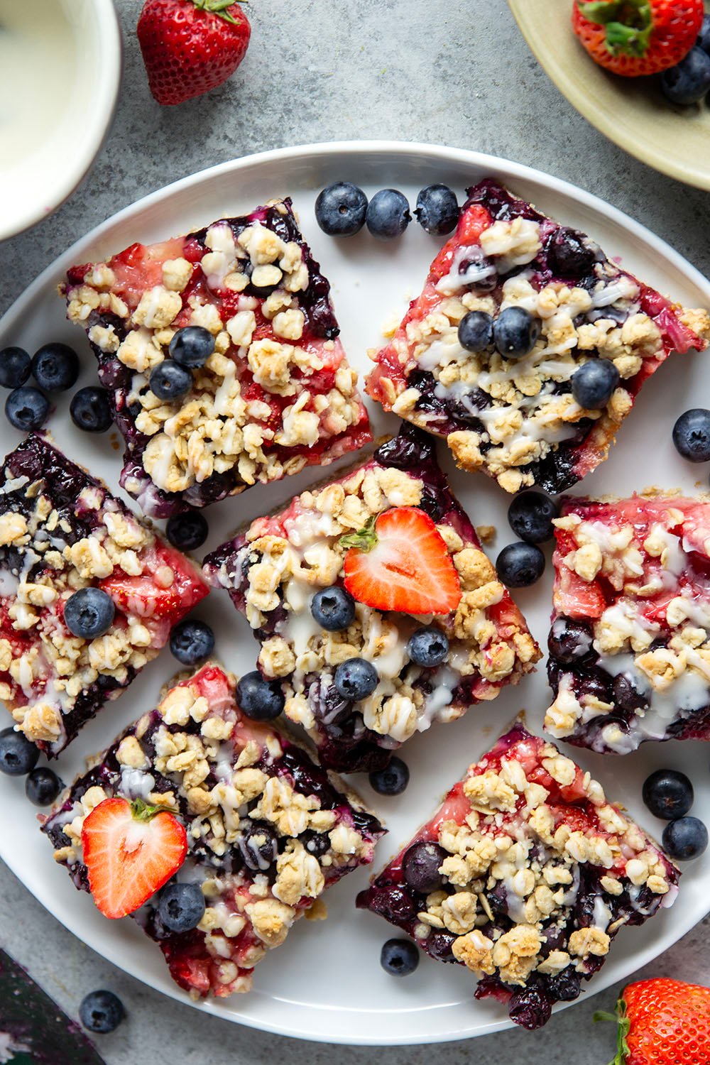 Loaded with a double whammy of berries, lots of streusel, and a creamy vanilla glaze, these red white and blue bars are an easy, festive treat for the 4th of July!
