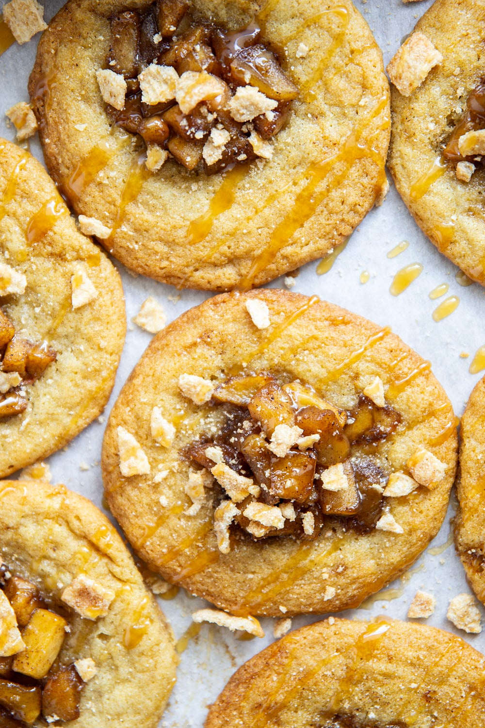 These caramel apple pie cookies feature a soft and chewy butter cookie base with a caramelized apple center, rich drizzles of caramel sauce, and crushed cinnamon crunch cereal on top.