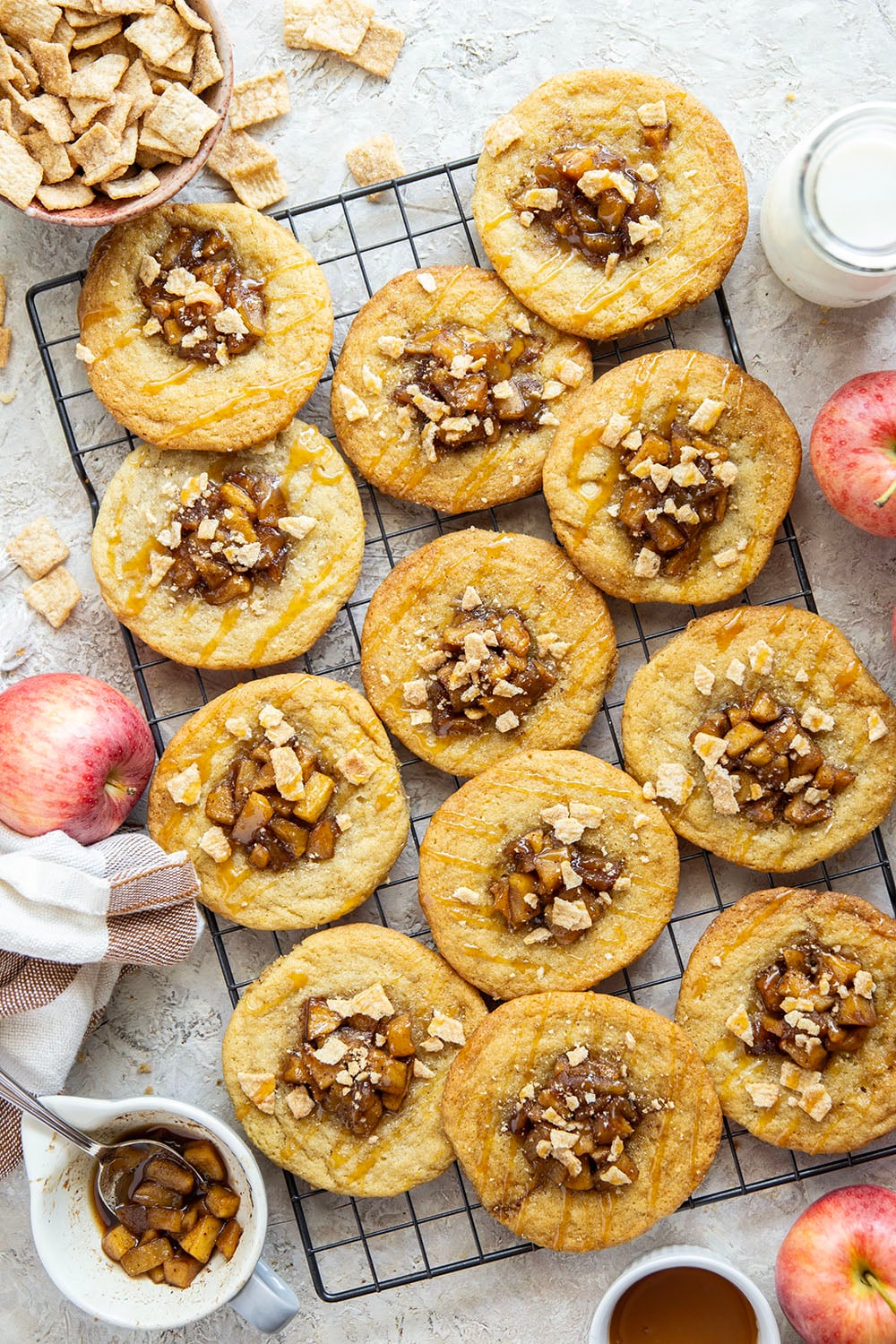These caramel apple pie cookies feature a soft and chewy butter cookie base with a caramelized apple center, rich drizzles of caramel sauce, and crushed cinnamon crunch cereal on top.