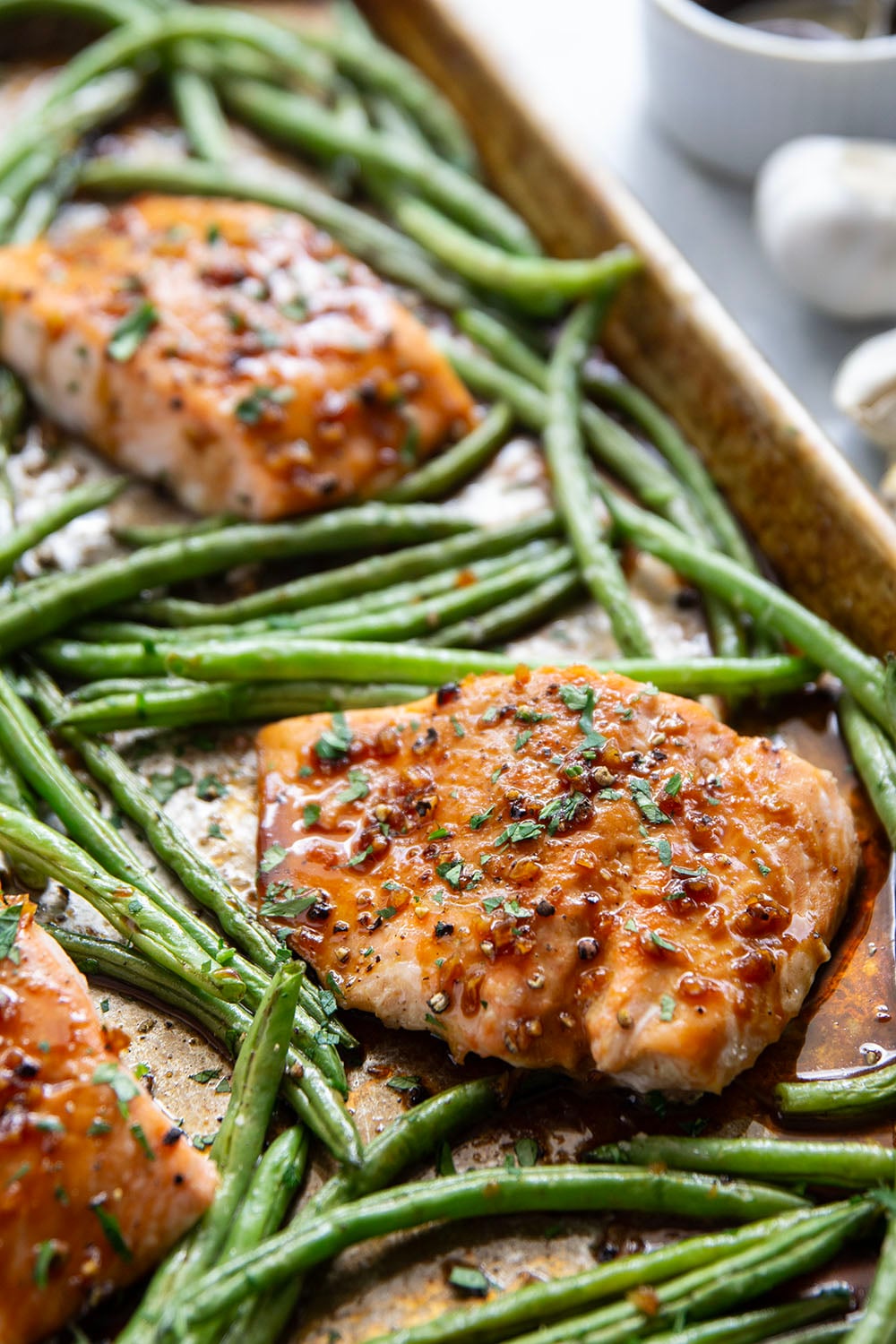 Sweet and sticky honey garlic salmon is baked on one sheet pan alongside tender green beans for a mess-free, flavor-packed weeknight dinner!