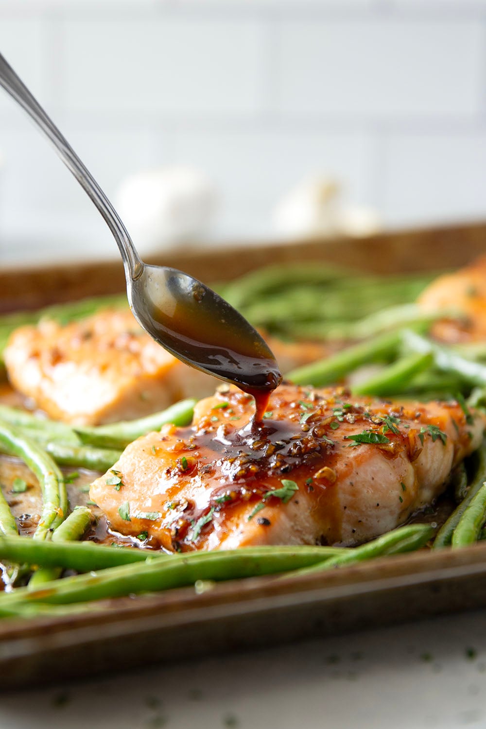 Sweet and sticky honey garlic salmon is baked on one sheet pan alongside tender green beans for a mess-free, flavor-packed weeknight dinner!