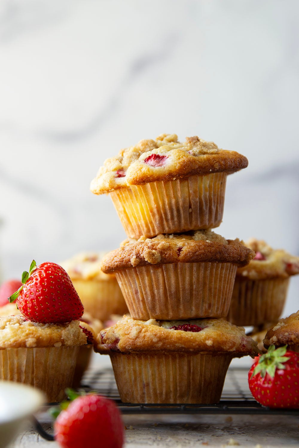 Packed with juicy strawberries, filled with a luscious cheesecake filling, and topped with a buttery crumb topping, these strawberry cheesecake muffins are the best of all worlds wrapped up into one muffin.