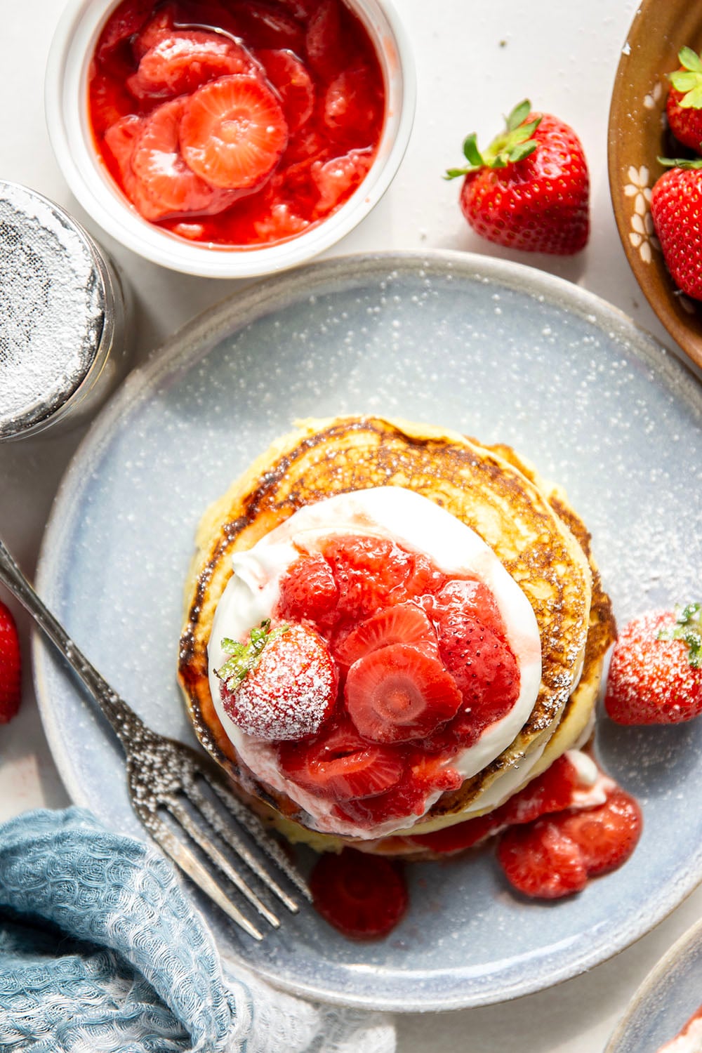 These strawberry shortcake pancakes feature layers of fluffy buttermilk cornmeal pancakes, fresh whipped cream, and lots of juicy fresh strawberry sauce.