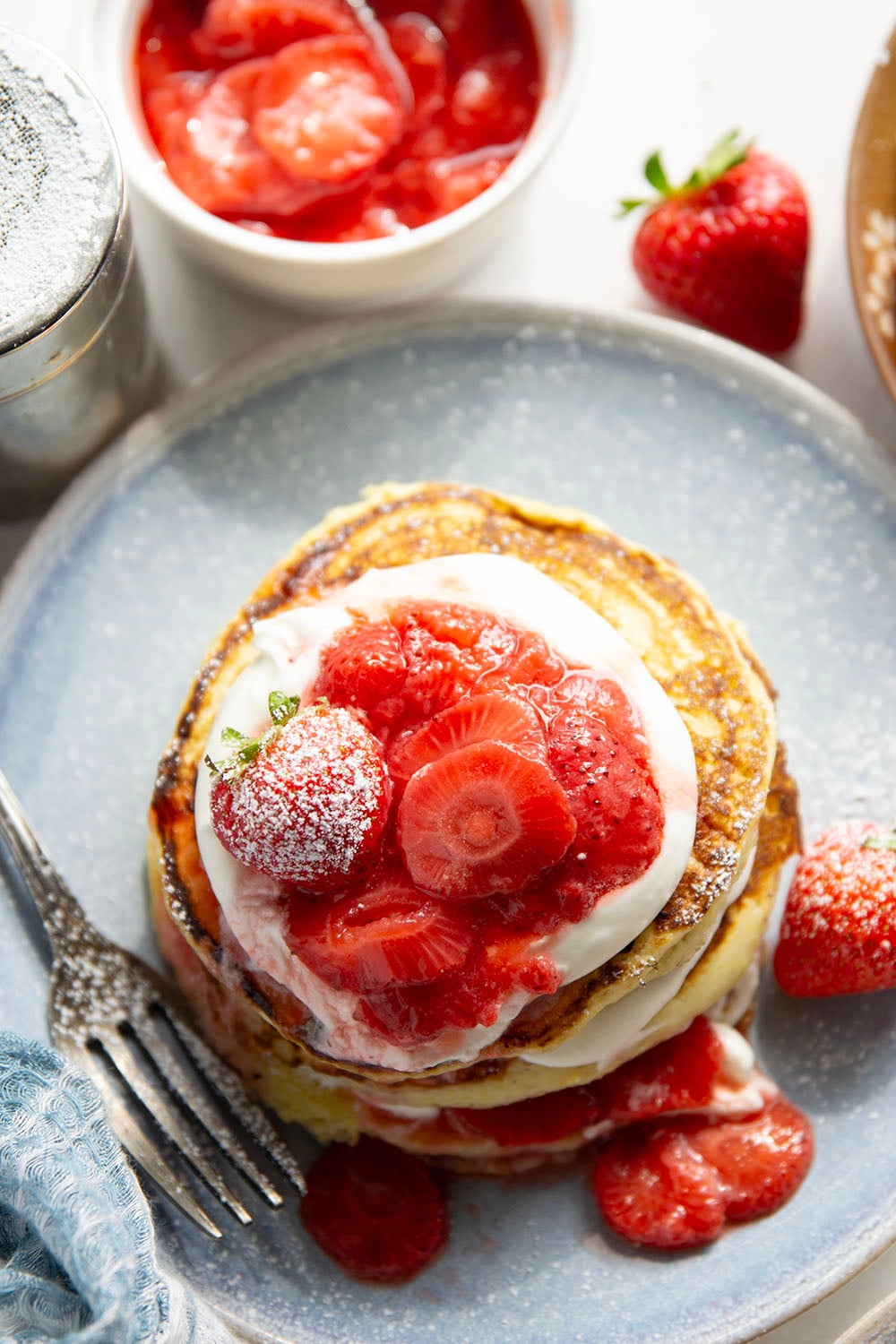 These strawberry shortcake pancakes feature layers of fluffy buttermilk cornmeal pancakes, fresh whipped cream, and lots of juicy fresh strawberry sauce.