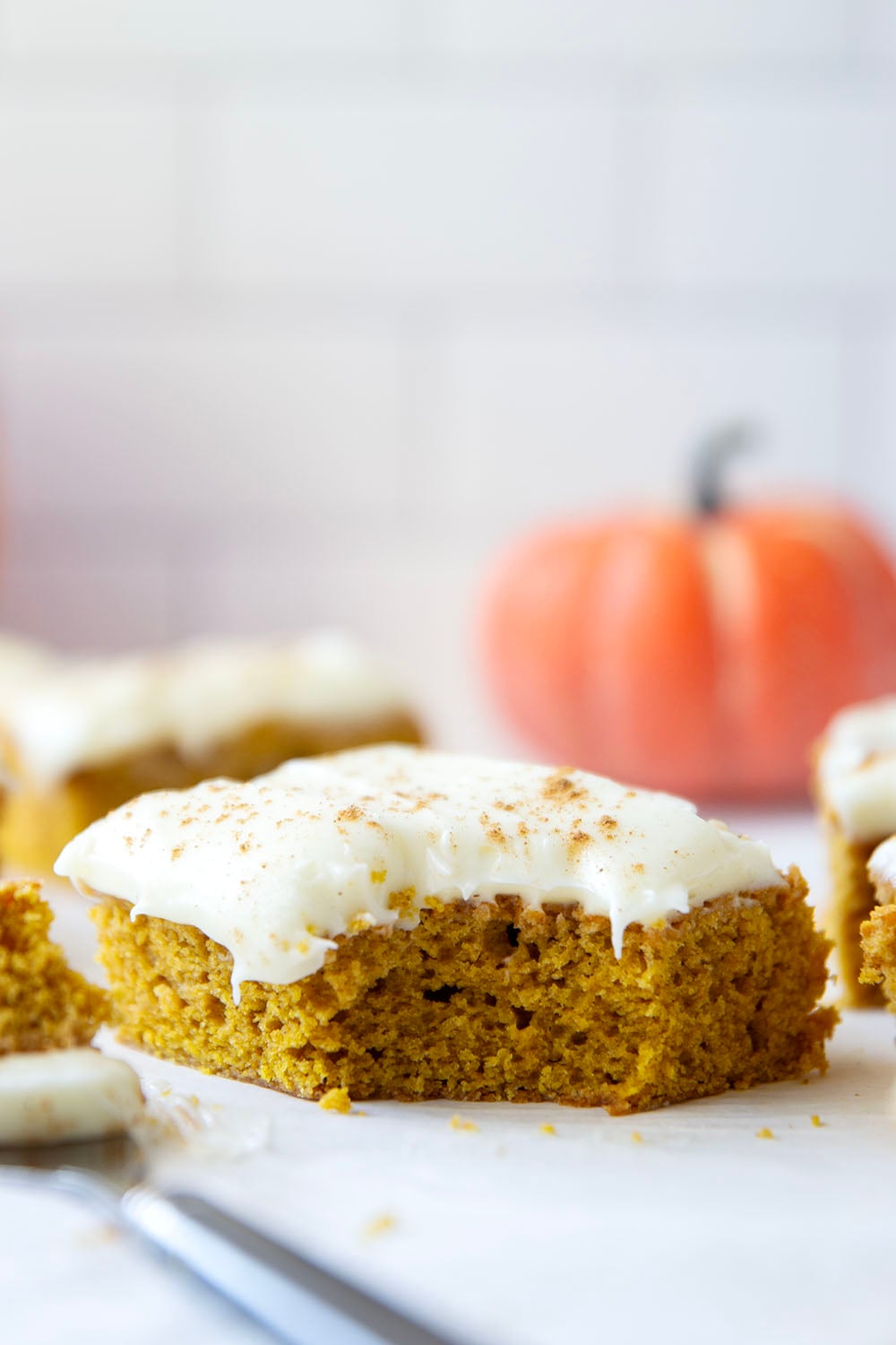 These pumpkin spice bars feature a soft, cake-like texture, lots of pumpkin spice goodness, and a silky cream cheese frosting on top.