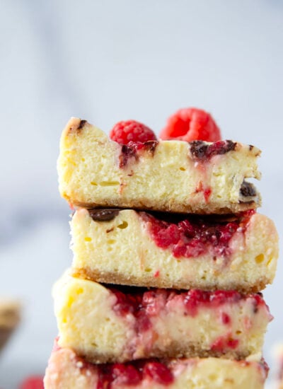 Chocolate raspberry cheesecake bars feature a silky cheesecake filling baked on top of a buttery graham cracker crust with with luscious swirls of fresh raspberry sauce and rich chocolate.