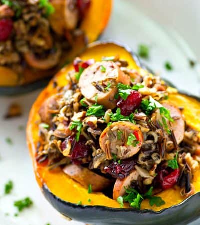 Tender roasted acorn squash boats are stuffed with a flavorful wild rice and sausage filling for a stunner fall side dish that goes great with roast chicken or turkey.