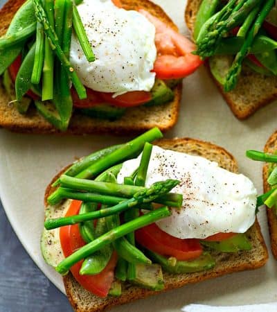 Avocado toast gets a spring upgrade!! This easy farmers market-style avocado toast is packed to capacity with spring veggies and a pretty poached egg makes it an entire breakfast-in-one!