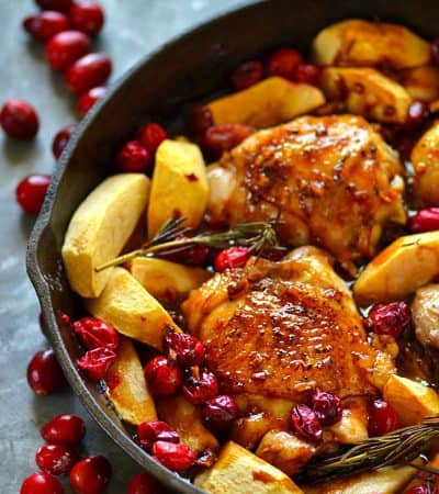 Juicy chicken thighs are roasted in tangy cranberries, soft apples, and covered in a sweet maple glaze for the EASIEST way to do chicken holiday-style!