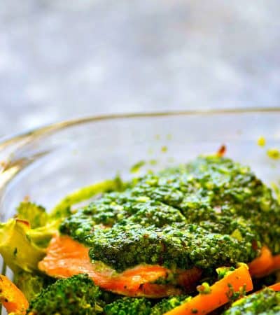 Smothered in flavorful basil pesto and roasted with broccoli and sweet peppers, this pesto baked salmon is on the dinner table in MINUTES and super filling, yet light on the carbs!