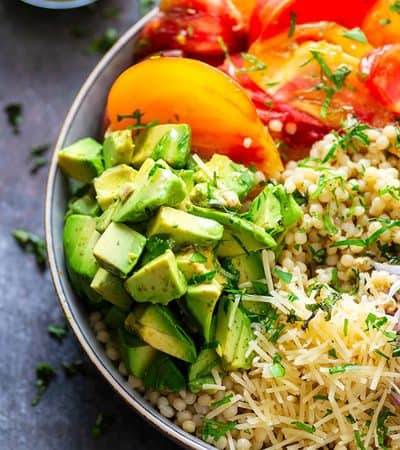 Juicy fresh heirloom tomatoes and silky avocado bring incredible summer flavors to this colorful Israeli couscous salad that's easy to throw together and a STUNNER for any summer table!
