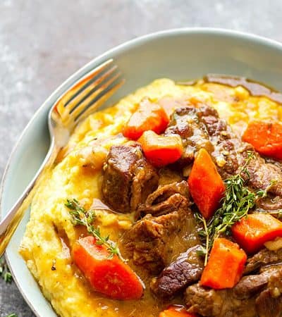 Stout-Braised Beef Short Ribs - Saucy and incredibly tender stout-braised beef short ribs are piled high over creamy bowls of mascarpone polenta for the ultimate AND surprisingly easy cold weather comfort food!