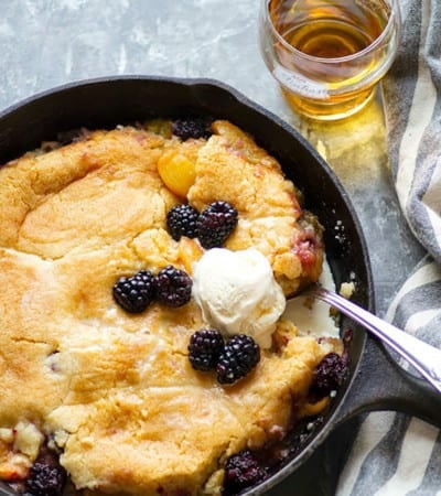 Classic peach blackberry cobbler is the ultimate dessert ode to summer! Flavorful brandy is tossed in the fruit filling with even more brushed on top hot from oven. Serve this beautiful cobbler with plenty of vanilla ice cream!