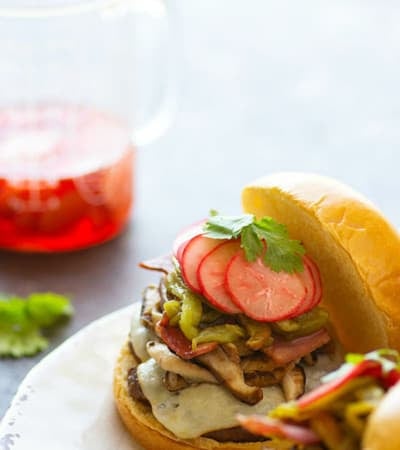 Green chile cheeseburgers are piled high with flavorful roasted chiles, tender shiitake mushrooms, and crispy bacon for the ultimate take on this burger classic!