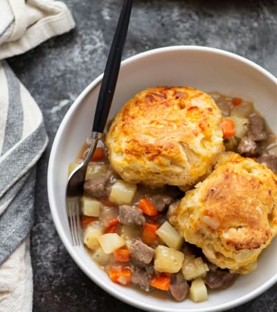 Loaded with steak and potatoes in a rich beer sauce and topped with buttery cheddar biscuits, this steak pot pie is an irresistible weeknight comfort food!