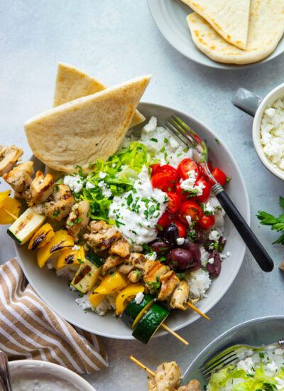 These chicken souvlaki bowls feature flavorful grilled chicken and vegetable skewers in hearty rice bowls with homemade tzatziki sauce and lots of toppings.