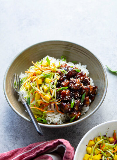 Korean BBQ tofu bowls feature perfectly crisp and saucy tofu piled over fluffy rice with a sweet and spicy mango slaw on top.