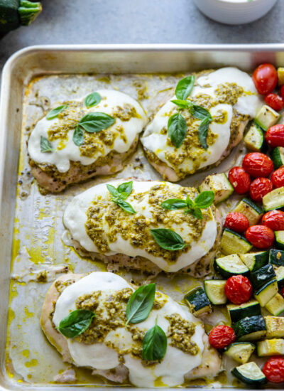 Made entirely on one sheet pan in under an hour, this pesto mozzarella chicken roasts up with plenty of flavorful pesto, tender zucchini, and bursting cherry tomatoes.