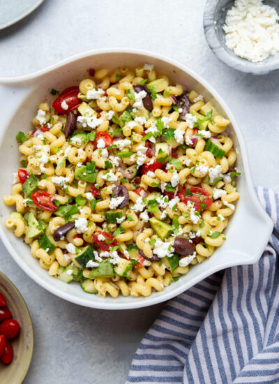 This pasta salad features tender pasta and tons of fresh Greek ingredients tossed in a flavorful lemon herb vinaigrette for an easy standout side dish!