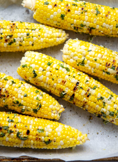 This grilled corn cooks up perfectly sweet and tender in minutes on the grill and is amazing brushed with a flavorful basil butter!