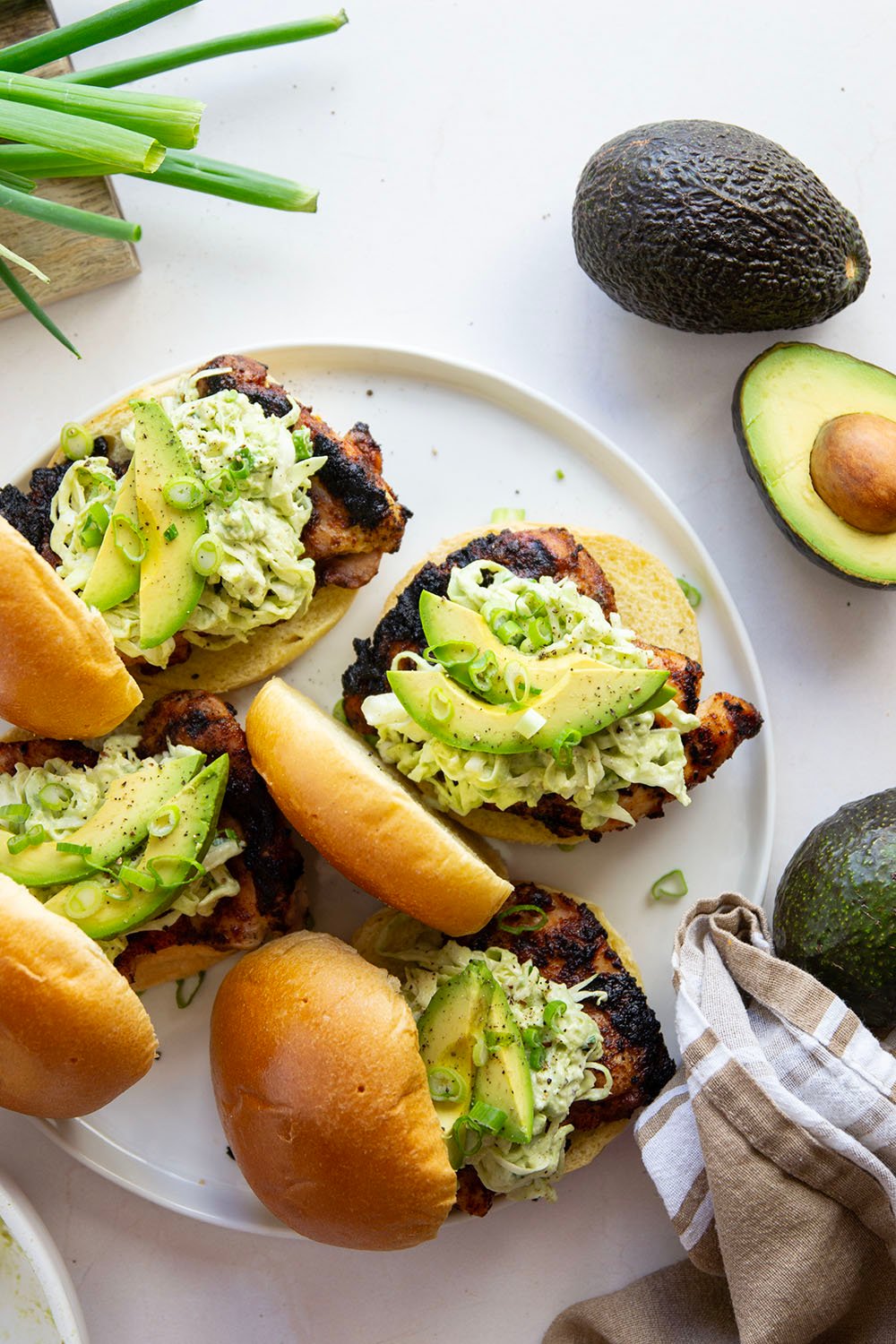 Juicy grilled blackened chicken thighs are stuffed between buns with lots of creamy avocado slaw. This blackened chicken sandwich will quickly become a favorite!