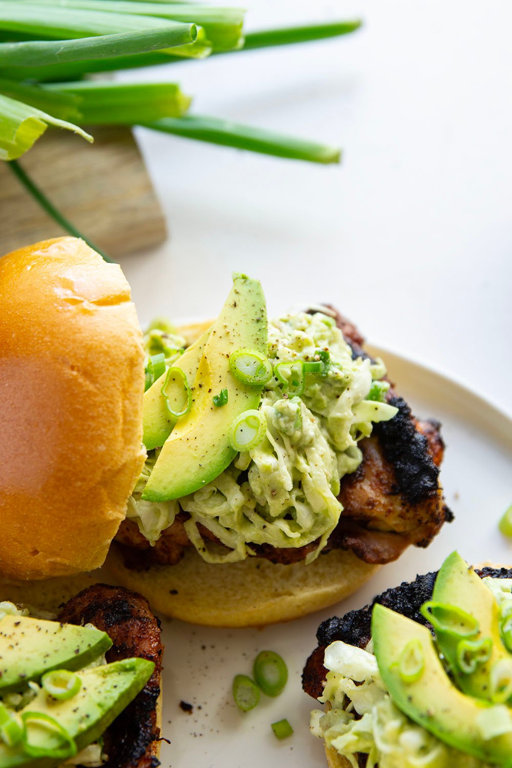 Juicy grilled blackened chicken thighs are stuffed between buns with lots of creamy avocado slaw. This blackened chicken sandwich will quickly become a favorite!