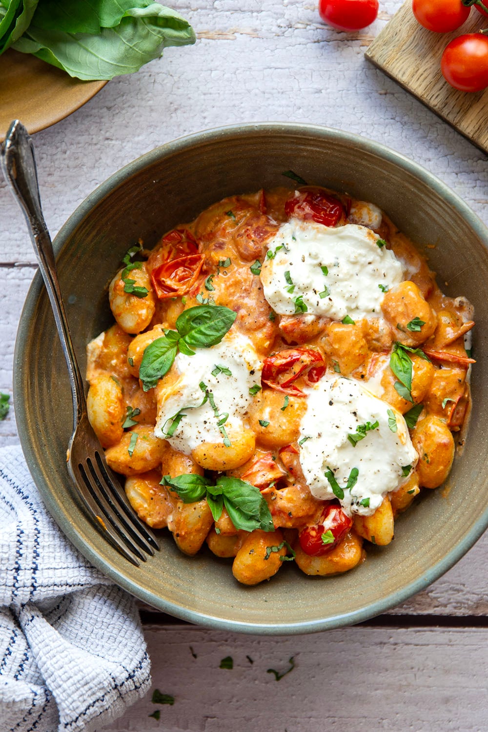 A creamy fresh cherry tomato sauce coats every inch of pillowy gnocchi in this summery burst tomato gnocchi that's topped with lots of fresh basil and rich burrata cheese.