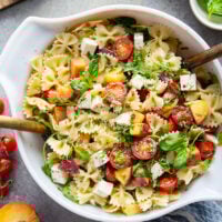 Sweet peaches pair perfectly with herby basil, soft mozzarella, juicy cherry tomatoes, and a tangy balsamic dressing in this peach caprese pasta salad.