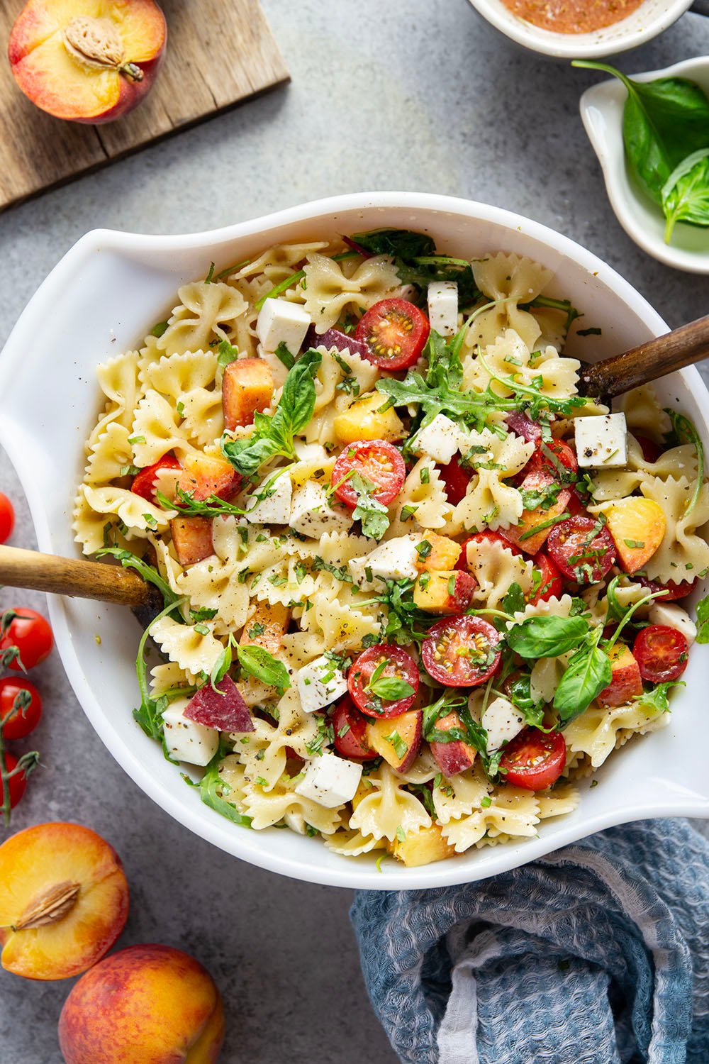Sweet peaches pair perfectly with herby basil, soft mozzarella, juicy cherry tomatoes, and a tangy balsamic dressing in this peach caprese pasta salad.