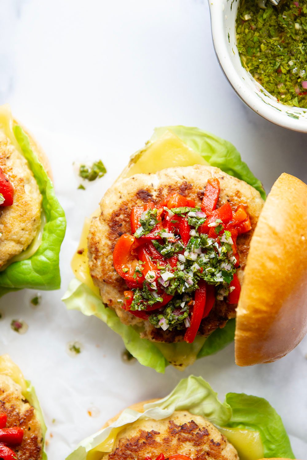 Topped with tender roasted red peppers and a flavorful chimichurri sauce, these cheddar turkey burgers are the perfect summer sandwich.
