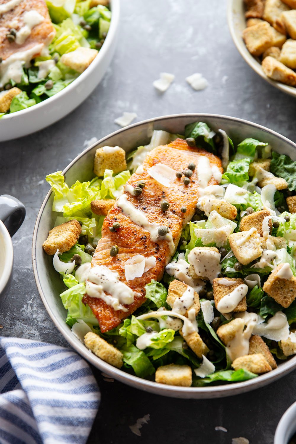 Buttery seared salmon fillets are the perfect meat pairing in this protein-packed seared salmon Caesar salad that features a creamy roasted garlic dressing on top.