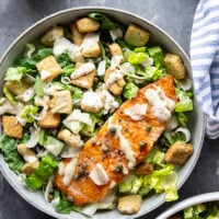 Buttery seared salmon fillets are the perfect meat pairing in this protein-packed seared salmon Caesar salad that features a creamy roasted garlic dressing on top.