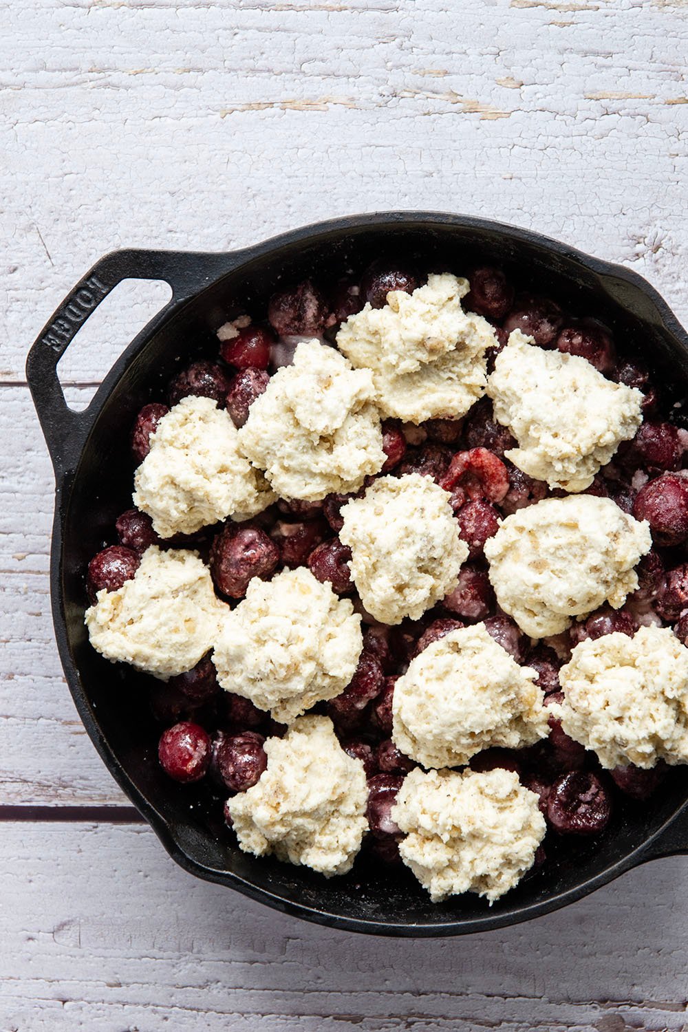 This cherry cobbler features a juicy fresh cherry filling baked with flaky browned butter biscuits on top. An incredible summer dessert warm from the oven with vanilla ice cream on top!