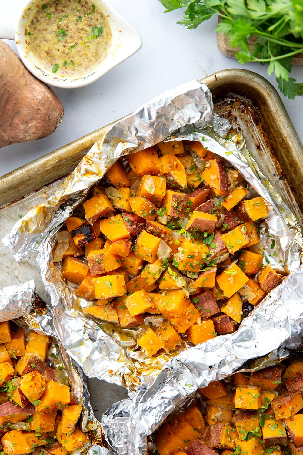 Tossed in a homemade honey mustard and grilled to tender, smoky perfection in foil packets, these grilled sweet potatoes in foil are an easy side dish to throw on the grill for any occasion.