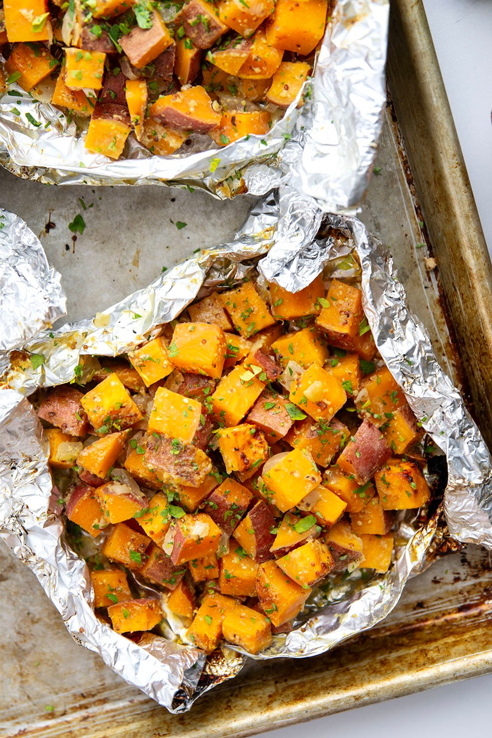 Tossed in a homemade honey mustard and grilled to tender, smoky perfection in foil packets, these grilled sweet potatoes in foil are an easy side dish to throw on the grill for any occasion.